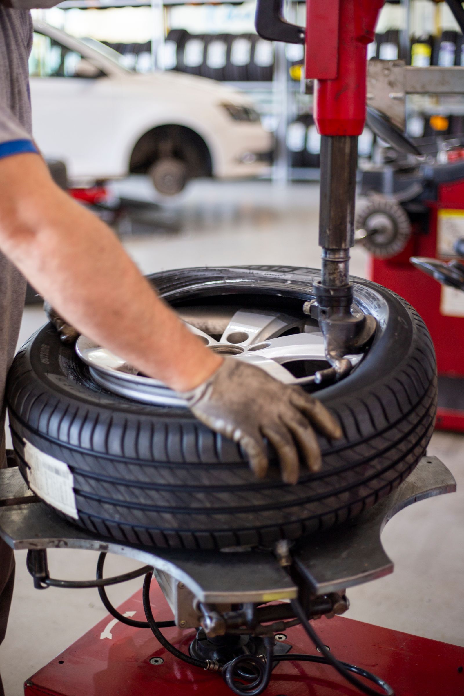 Technician changing a vehicle tire with workshop equipment